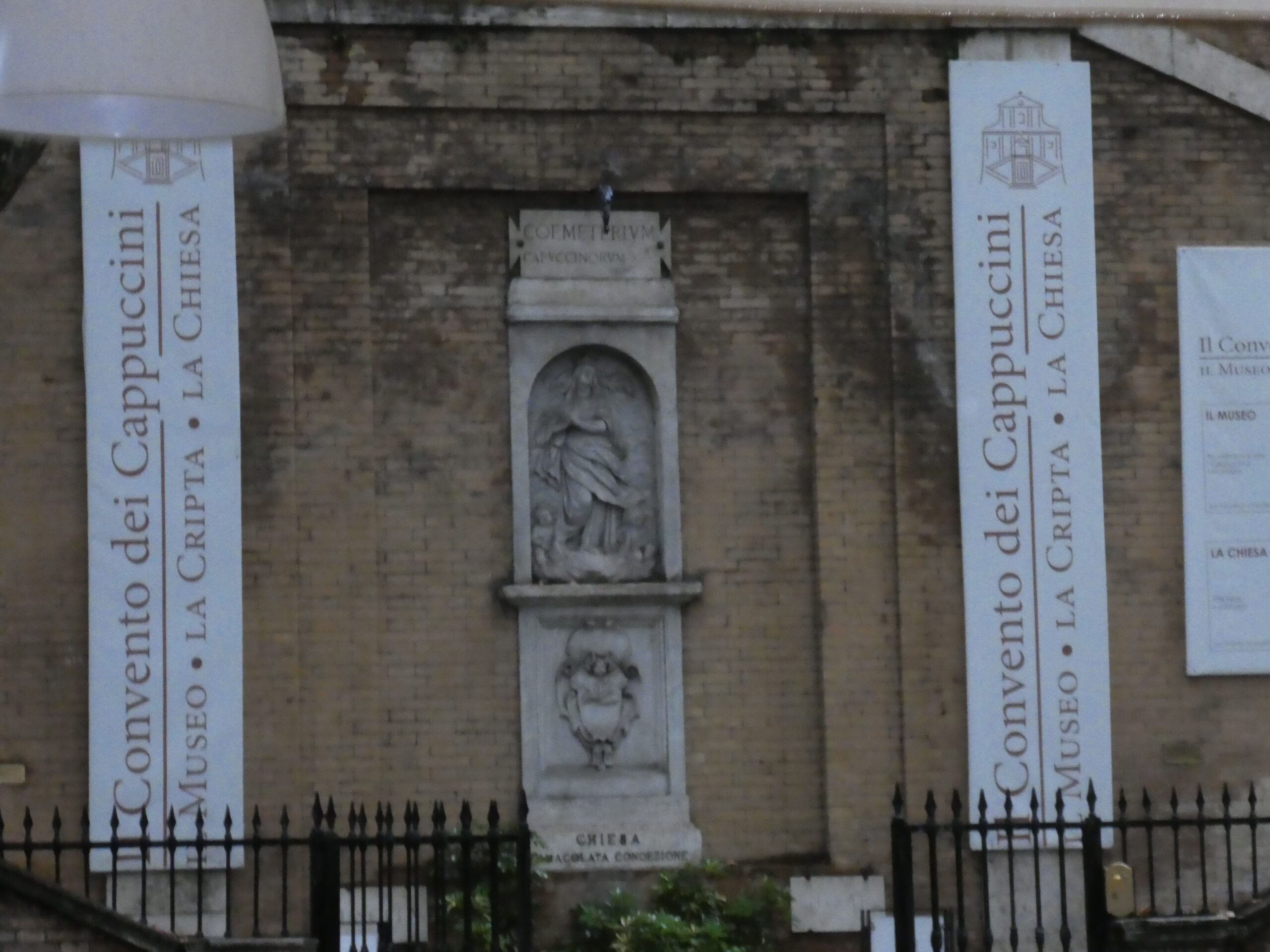 Eingangsbereich der Kapuzinergruft in Rom mit Hinweisschildern zu Museum, Krypta und Kirche