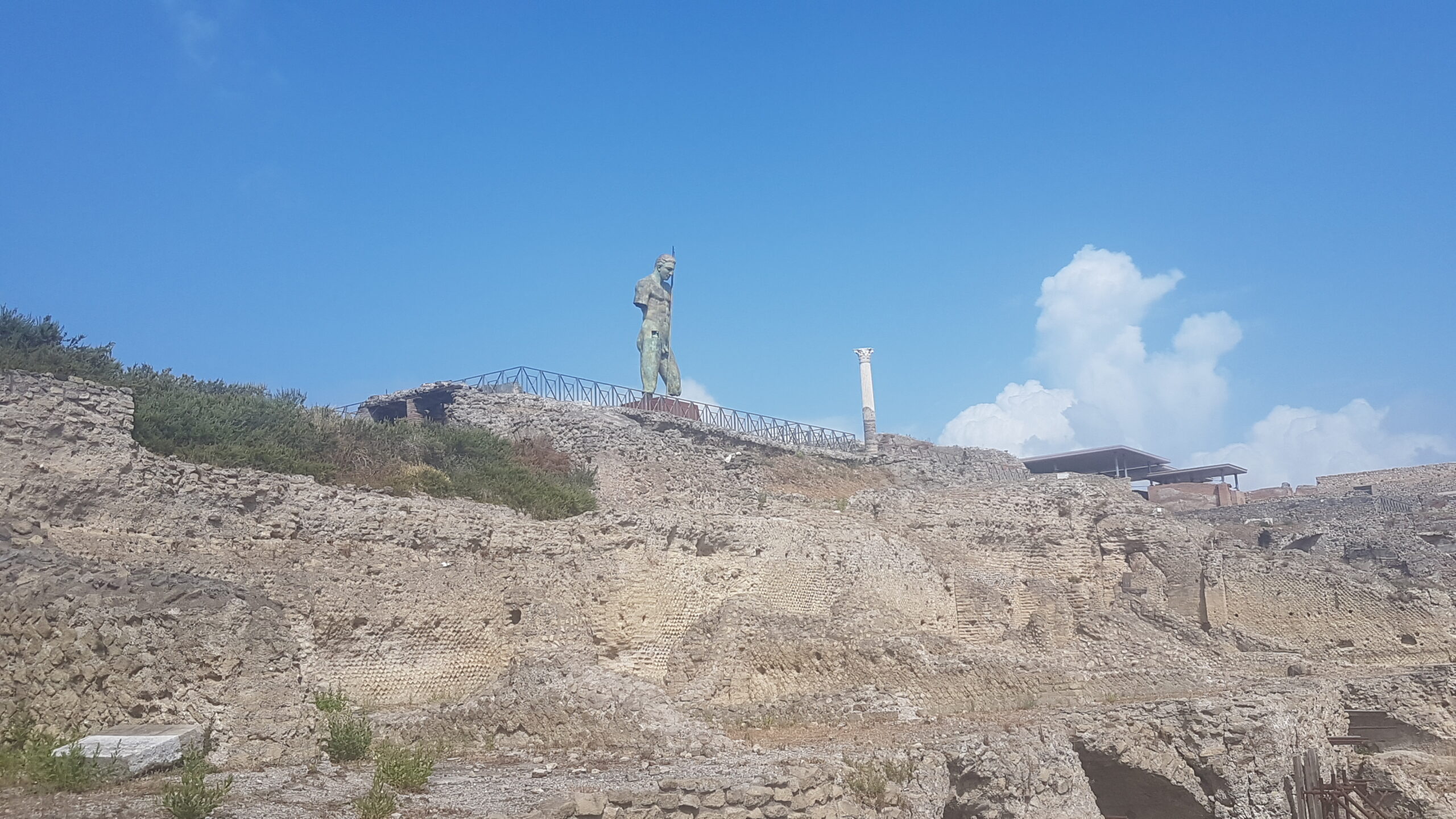 Bronzestatue und antike Säule in der Ausgrabungsstätte Pompeji